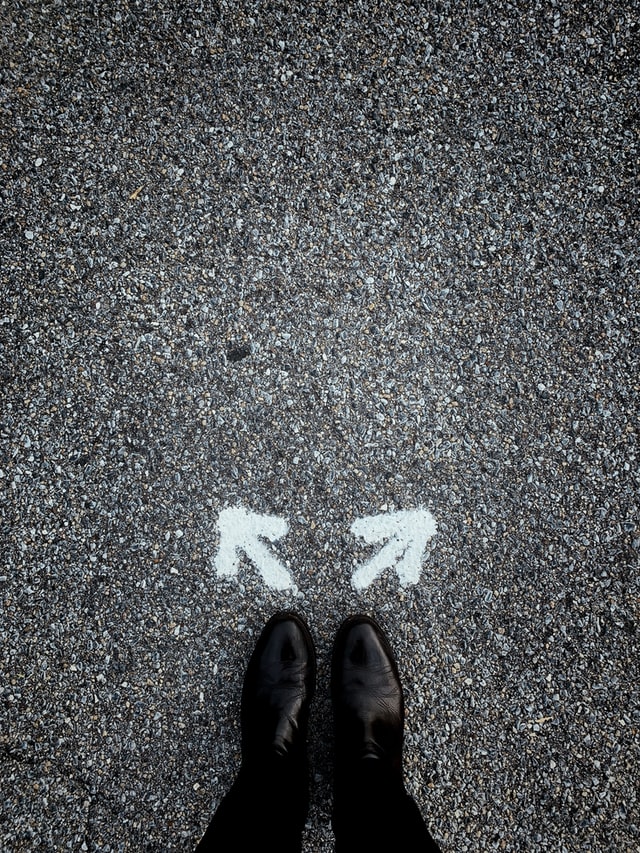 Duas setas no chão representando uma escolha de qual caminho fazer